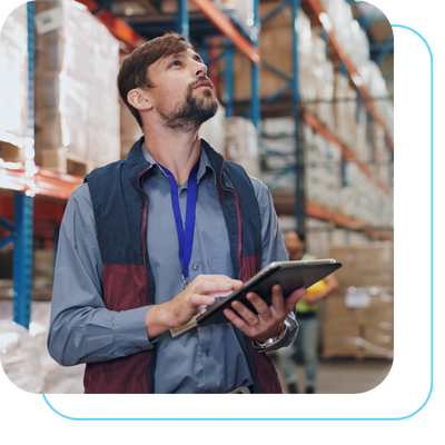 Gestor logístico dentro de armazém com tablet na mão fazendo o planejamento logístico de 2026